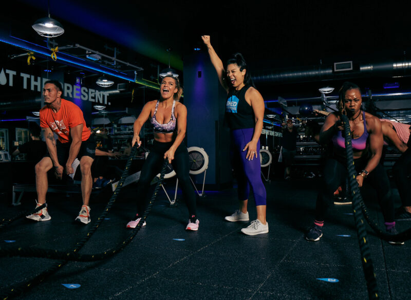 People working out with ropes in a group fitness class