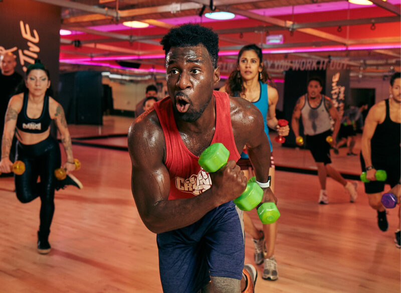Man using dumbbells in a group fitness class