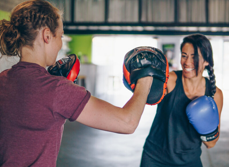 woman with a boxing trainer