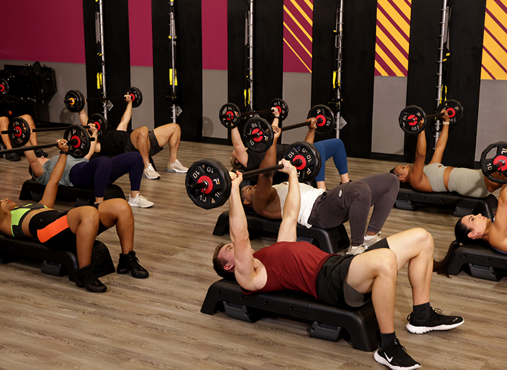 people in a workout class using barbells